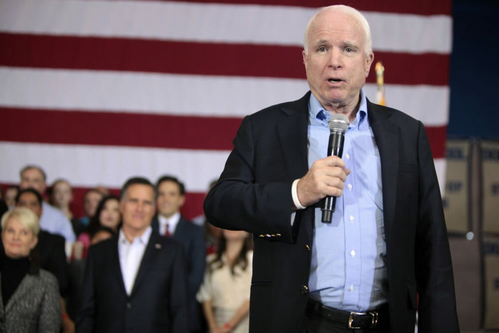 John McCain speaks in front of the American flag.