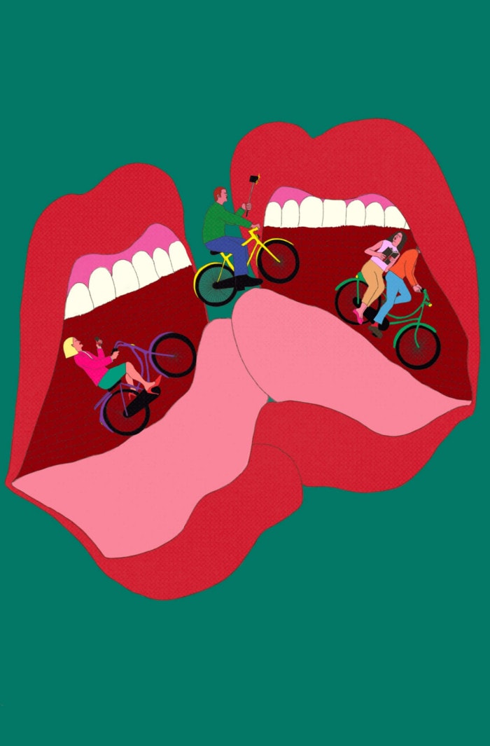 Two mouths kissing. Four bicyclists ride up and down the tongues.